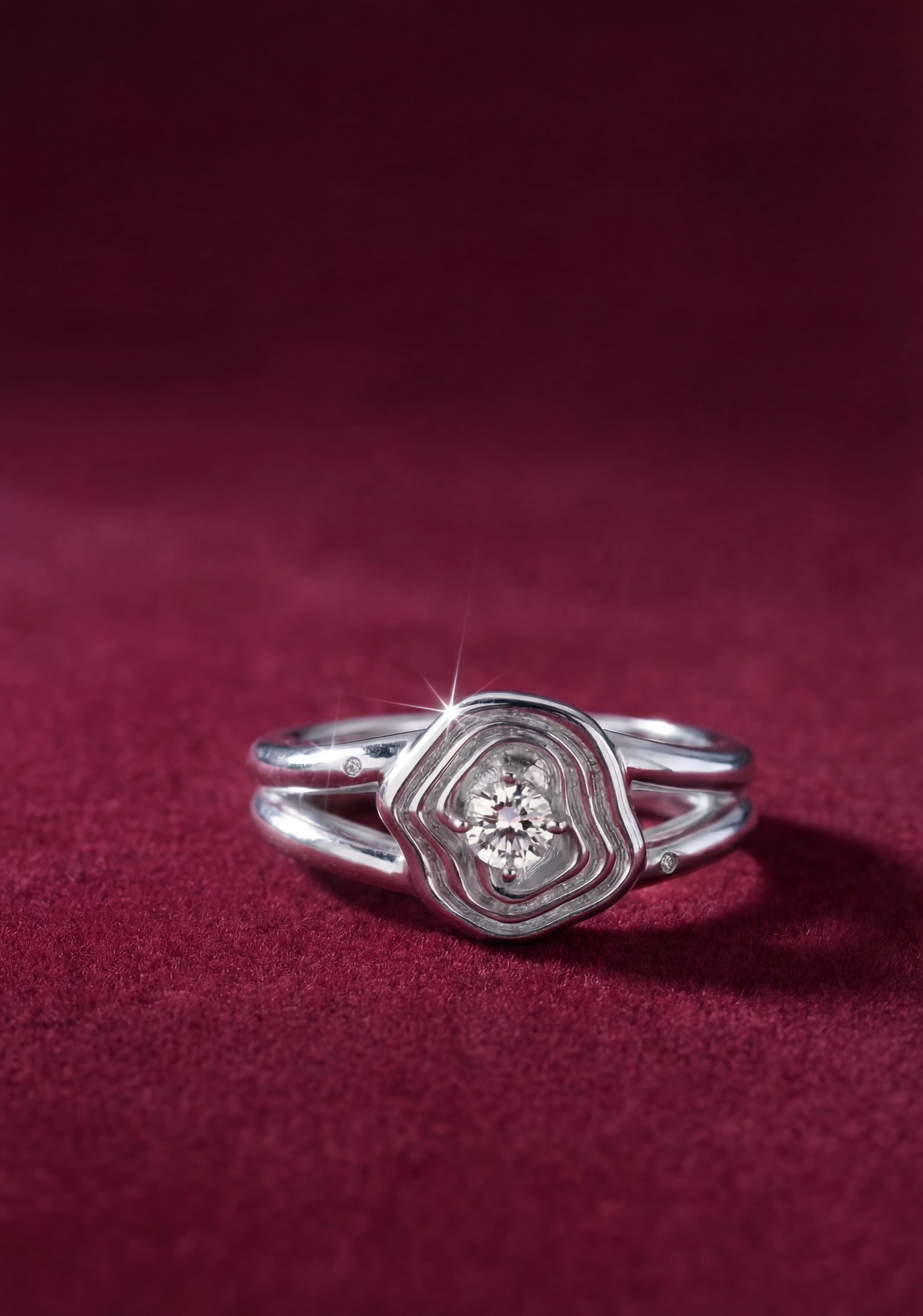 Silver ring with a diamond on a red fabric background