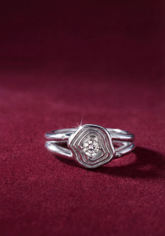 Silver ring with a diamond on a red fabric background