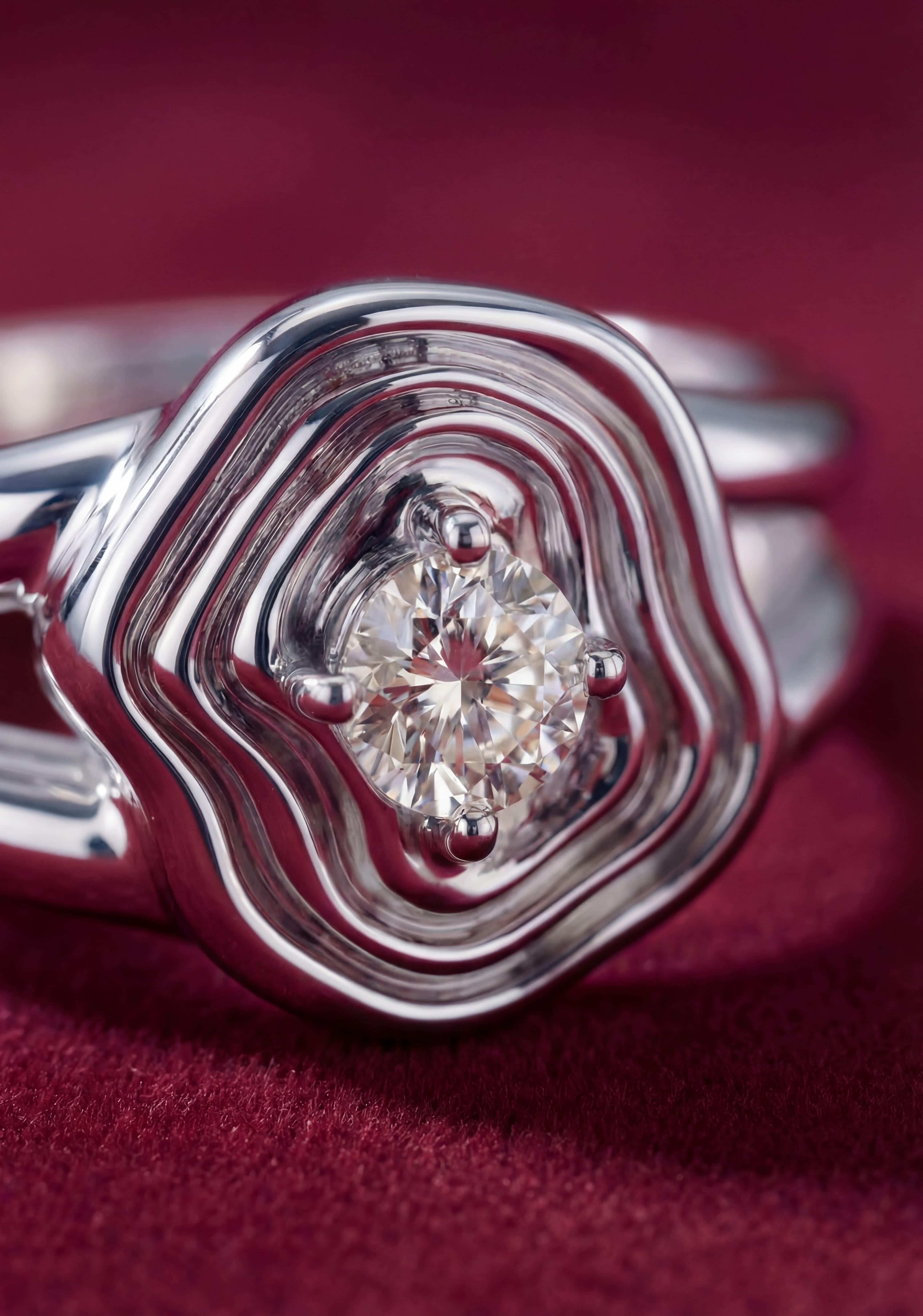Silver ring with a diamond on a red fabric background